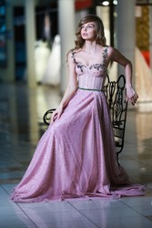 Beautiful blonde woman in a pink evening long dress. Romantic image