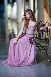 Beautiful blonde woman in a pink evening long dress. Romantic image