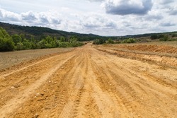 Clearing, grading, leveling and clearing of vegetation on land field for the construction of road or highway