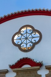 Symmetrical architectural decorative detail and openwork in the shape of a clover on the facade of a house