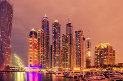 Dubai, United Arab Emirates: skyscrapers of famous Marina at night. This is an artificial canal city, built along a stretch of Persian Gulf shoreline. Fireworks in the background of  picture. 