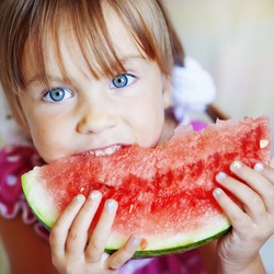 Funny child eating watermelon closeup