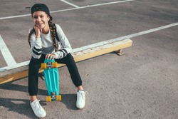 11-12 years old tween girl wearing fashion sportswear rollerskating on skateboard in the city street, urban hipster style