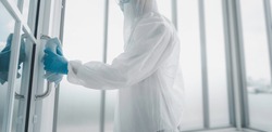 Man in virus protective suite and mask cleaning covid19 infected area, Virus disinfection concept