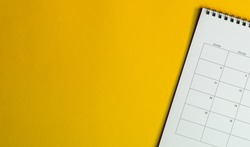 Calendar or planner on yellow background with copy space. Business schedule concept.