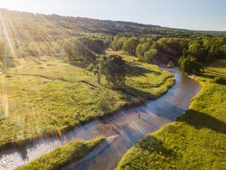 Drone aerial shot of a man fly fishing in the summer in a river