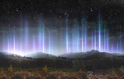 Beautiful colorful light pillars at night over the mountains