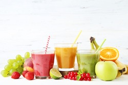 Healthy smoothie in glasses with fruits and vegetables on wooden background