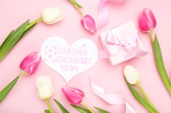 Tulip flowes, card in shape of heart with text 8 March Womens Day and gift box on pink background