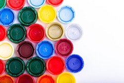 Plastic bottle caps on white background. Cap material is recyclable. Recycling collection and processing plastic bottle caps. Remove lids from plastic bottles before recycling them.