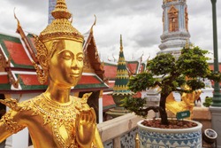 Golden Kinnari statue at Temple of Emerald Buddha (Wat Phra Kaew) in Grand Royal Palace. Half-bird, half-woman creature at south-east Asian Buddhist mythology. Bangkok, Thailand