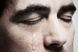 Crying man with tears on face closeup