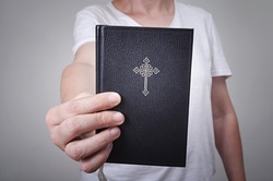 Male hand with Holy Bible book. Freedom of religion concept.