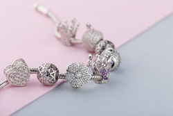 Bracelet with silver charm beads with gems. Flower, crown, ball, heart beads.  Product concept for jeweler