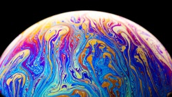 Virtual reality space with abstract multicolor psychedelic planet. Closeup Soap bubble  like an alien planet on black background
