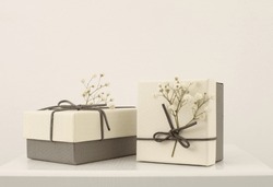 Craft gift boxes with flower on light beige background. Copy space minimalism style template background. 