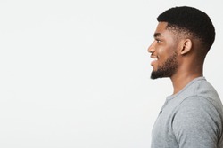 Happy smiling african-american man profile portrait. Black guy looking aside at copy space