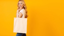 Ecology Concept. Woman With Blank Eco Bag On Yellow Studio Background, Free Space