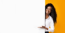 Awesome promo. Smiling african american woman presenting something on white blank board with empty space, panorama