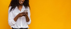 New useful application. Black woman using cellphone on yellow background, free space