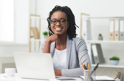 Successful Businesswoman. Afro Girl Sitting At Laptop And Smiling In Modern Office. Empty Space For Text