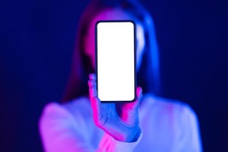 Mockup. Woman showing blank smartphone screen in studio with blue and pink neon lights, free space