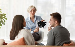 Marital Therapy. Professional Psychologist Showing Inkblot Picture Testing Couple During Family Counseling Sitting In Office. Selective Focus