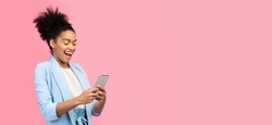 Amazing Application. Happy young black woman using cell phone isolated over pastel pink studio wall, copyspace