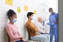 Coronavirus Vaccination. Diverse Patients People Waiting For Covid-19 Vaccine Sitting In Queue In Hospital Waiting-Room. Corona Virus Prevention, Medical Immunization Campaign. Selective Focus