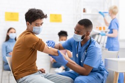 Covid-19 Vaccination. Asian Male Patient Getting Vaccinated Against Coronavirus Receiving Covid Vaccine Intramuscular Injection During Doctor's Appointment In Hospital. Corona Virus Immunization
