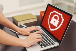 Blocked website or app and cyber security, ban or problems at work. Unrecognizable female hands typing on laptop enters login and password, at home or office with red screen and closed lock, close up