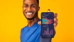 Cheerful black man demonstrating application on smartphone screen with sport activity progress data, recommending modern app for fitness tracking, standing over yellow background, creative collage