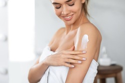 Body Care. Woman Applying Moisturizing Lotion Or Cream On Shoulders Caring For Skin At Home, Standing In Bathroom. Skincare And Pampering, Beauty Routine Concept. Cropped, Selective Focus