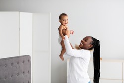 Black mom playing with her cute little baby