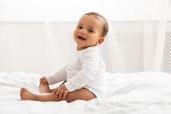 Portrait Of African Baby Toddler Smiling Sitting On Bed Indoor