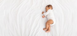 High-Angle View Of Baby Boy Sleeping On Side Lying In Bed Indoors. Cute Toddler Child Resting Napping During Daytime Sleep At Home Concept. Top View Shot. Panorama With Copy Space