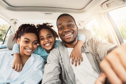 Joyful African American Family Hugging Sitting In Car During Summer Road Trip. Parents And Daughter Posing In New Auto Smiling To Camera. Transportation, New Automobile Concept
