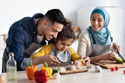 Young Arab Father Showing How To Chop Mushrooms To His Little Daughter While They Cooking Healthy Tasty Food Together At Home, Happy Muslim Family Of Three Enjoying Preparing Vegetarian Meal