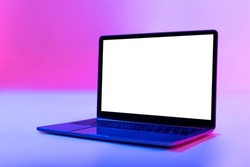 Modern laptop pc with empty white screen in neon light, space for website or desktop. Contemporary portable computer with template for advertisement. Mockup for user interface