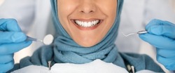 Dental Check Up. Closeup Shot Of Smiling Muslim Lady Getting Treatment In Stomatologic Clinic, Dentist In Blue Gloves Examining Teeth Of Islamic Lady In Hijab, Using Sterile Dental Tools, Cropped
