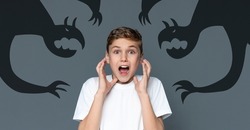 Screaming Teen Boy Scared Of Shadow Monsters Drawn Around Him, Creative Collage For Phobias And Inner Fears With Terrified Teenage Guy Shouting At Camera, Kid Suffering Nightmare, Panorama