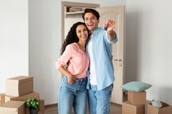 House Ownership. Portrait Of Happy Young Couple Holding Showing Key Standing In New Flat, Cheerful Guy And Lady Posing Hugging After Moving In Own Apartment. Insurance, Real Estate, Mortgage Concept