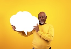 Senior black man holding empty speech bubble on orange studio background, mockup. Eldelry African American male with blank word cloud, free space. News, dialog, announcement concept