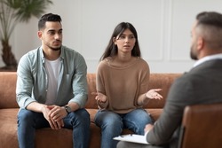Portrait of serious young lady talking to psychologist counselor complaining on bad relationship with husband, family couple counseling having conversation about problem at therapy session