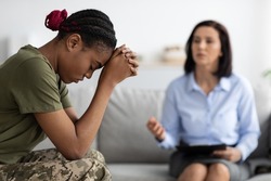 Posttraumatic stress disorder. Depressed black soldier woman attending therapy session with psychotherapist, african american military lady suffering psychological trauma after army, selective focus