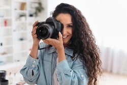 Professional Photographer Lady Taking Photo Smiling To Camera Holding Photocamera Standing Indoors. Modern Photography Art And Creative Professions Concept