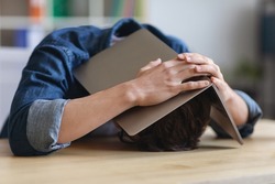 Portrait Of Stressed Young Man Covering His Head With Laptop Computer While Sitting At Desk In Office, Unrecognizable Male Employee Suffering Business Problems And Depression, Closeup Shot