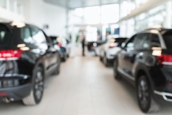 Vehicle purchase, rental, lease concept. Blurred view of automobile dealership store interior with new modern cars, copy space. Luxury showroom store with cars for sale, defocused shot