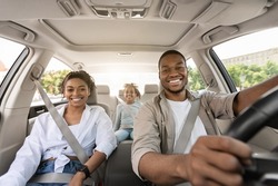 Black Parents And Daughter Posing Riding New Car Smiling To Camera Enjoying Road Trip. Family Having Vacation Traveling Together By Auto. Automobile Purchase Concept. Selective Focus