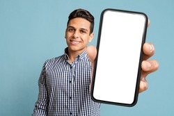Happy Handsome Young Latino Man Showing Modern Cell Phone With White Empty Screen And Smiling On Blue Studio Background, Recommending Dating App. Free Space And Mockup For Advertisement, Collage